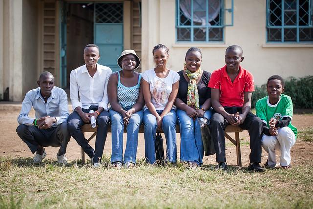 Group of smiling people sitting on a bench together